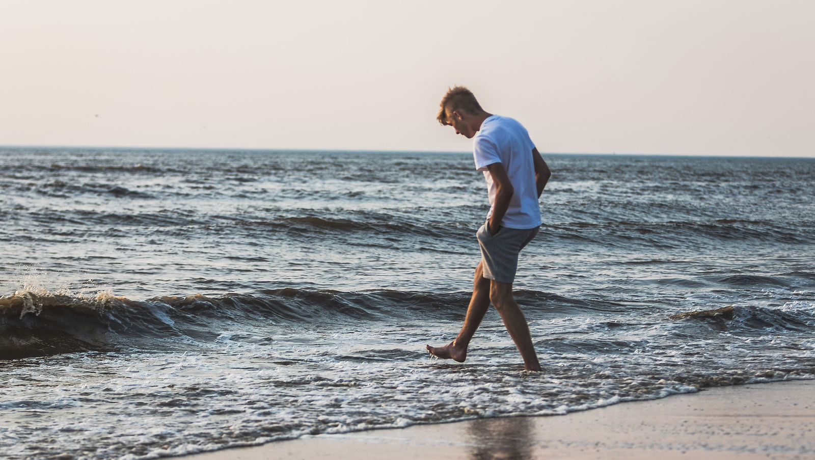 Man walking at beach near water